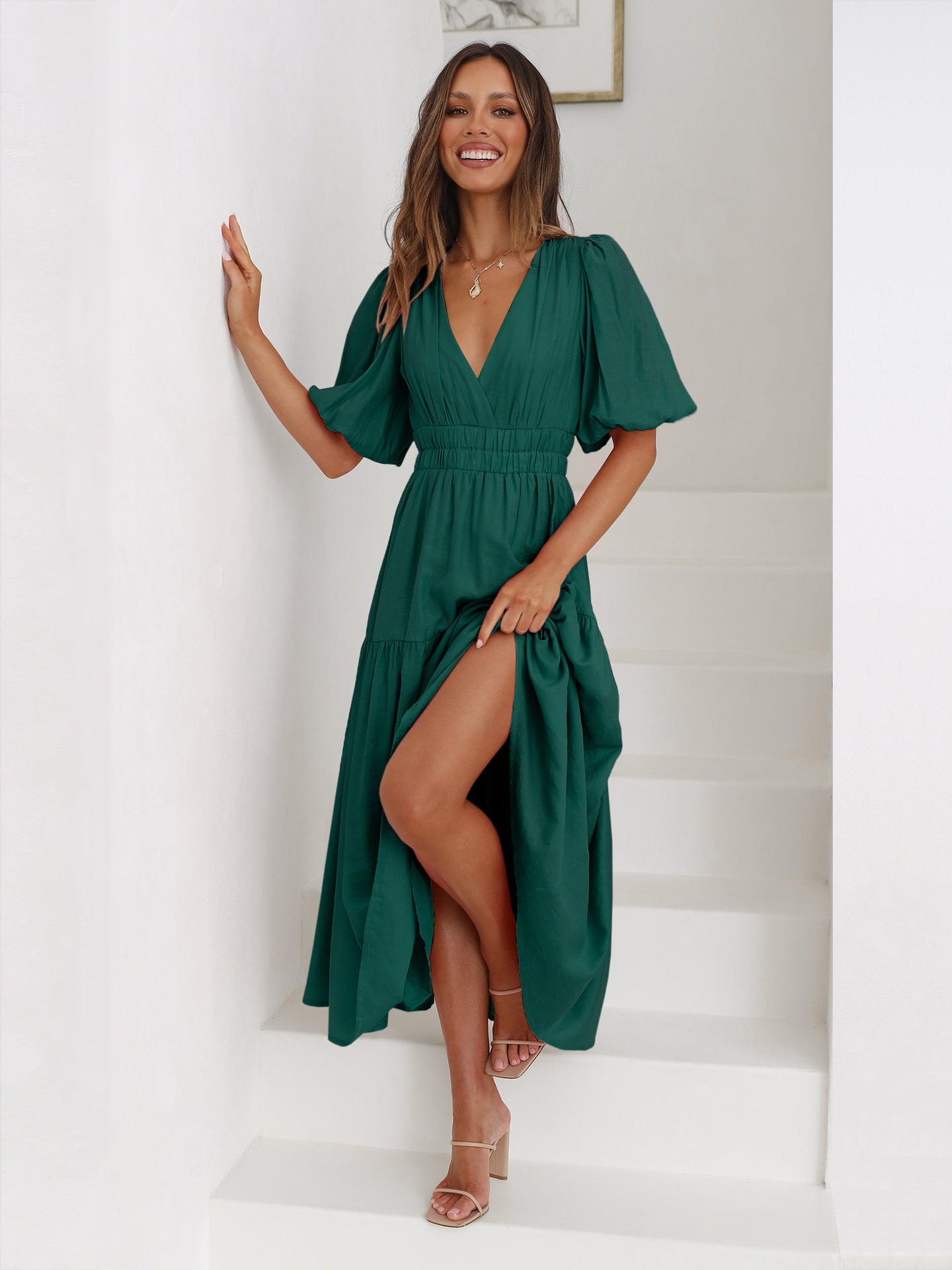 Vestido verde oscuro con escote en V profundo, mangas abullonadas y capas